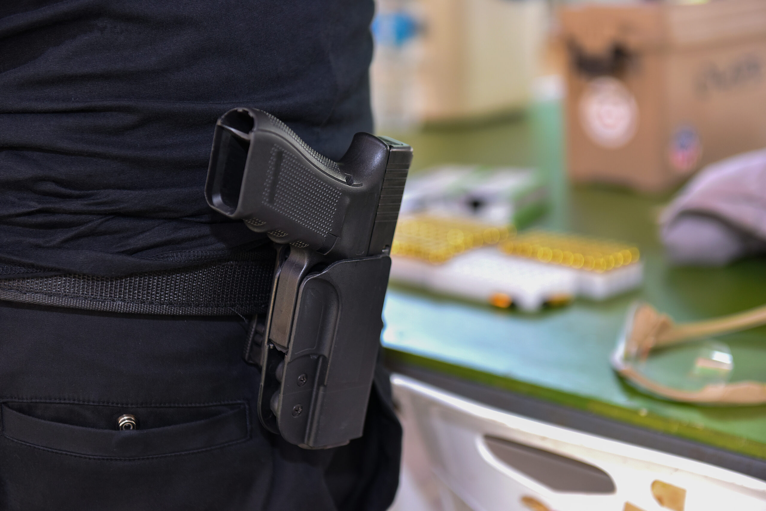 A person wearing a black shirt and holding a gun